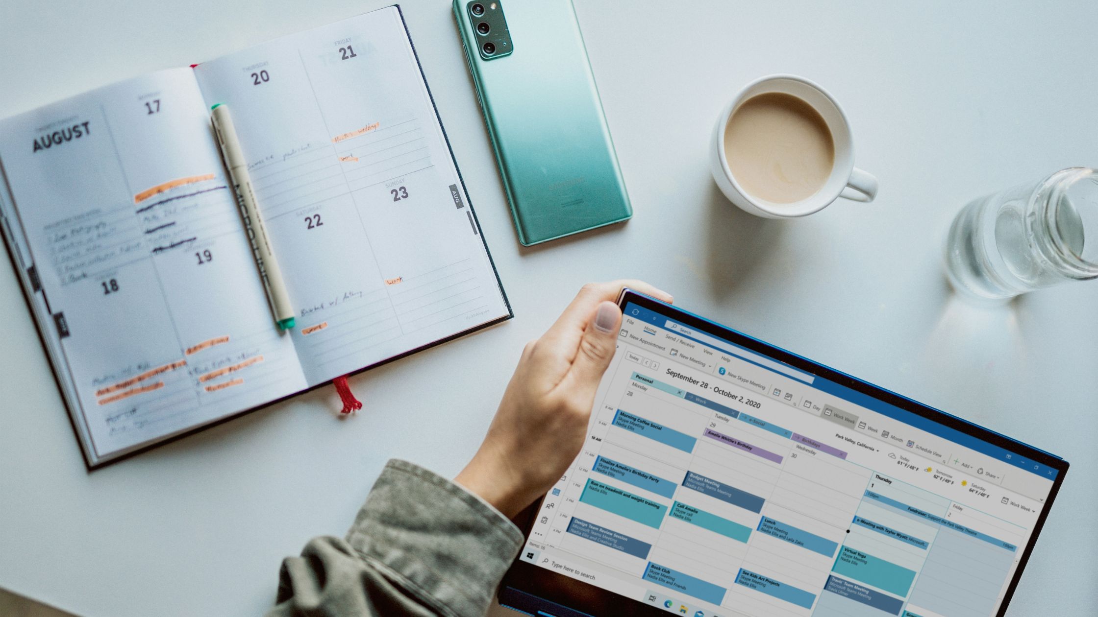 Time management: person organizing their schedule with a digital calendar and a notebook
